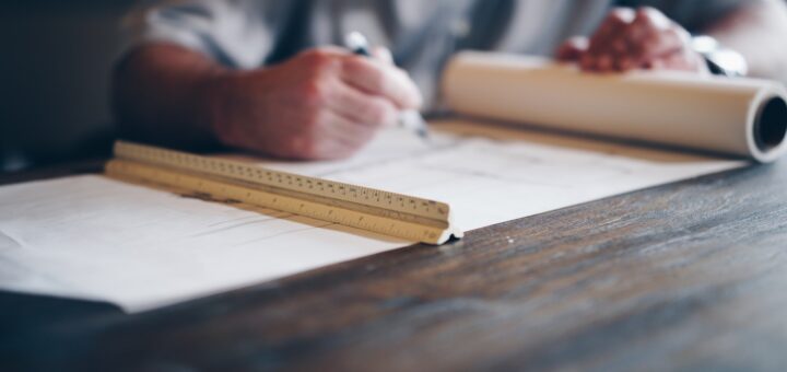 person drafting on blueprint